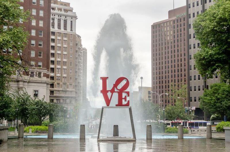 Brotherly love image showing a city square with the levers of love carved on a stature