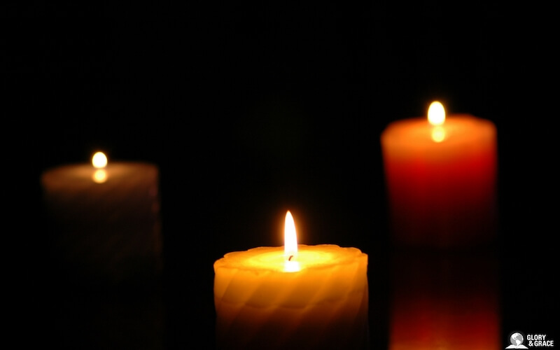 Darkness covering the earth showing three candles in the dark
