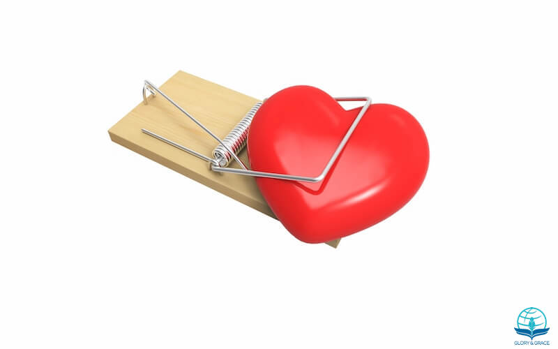 Trials and temptations showing a mouse trap and a red heart