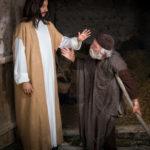 Divine healing showing Jesus praying for a man