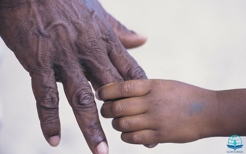 What is in your hand image showing a man holding the hands of a child