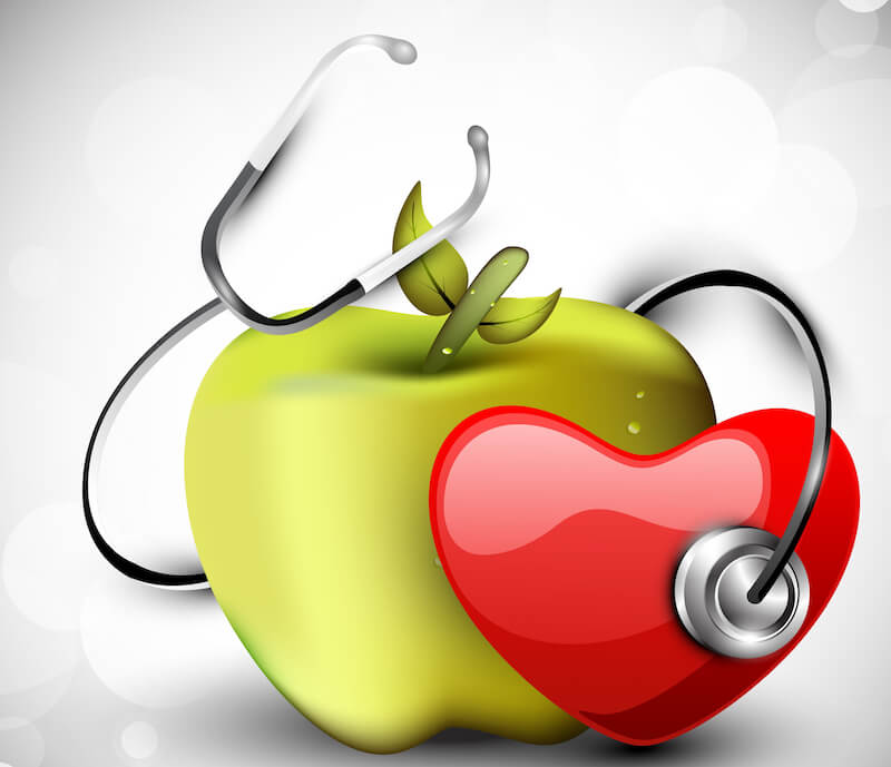 good health image showing an apple , stethoscope and a heart