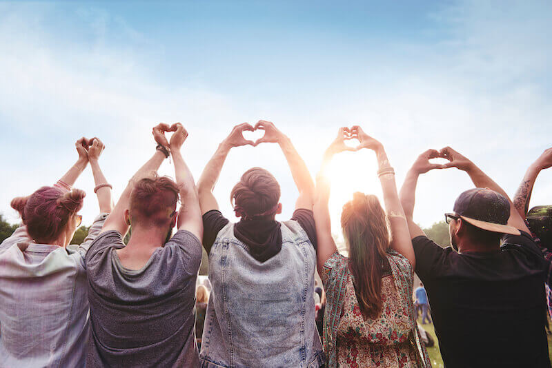 man believes with the heart showing a group of people making hearts with their fingers