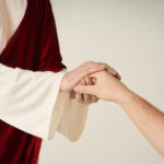 faithfulness showing a man holding Jesus hands