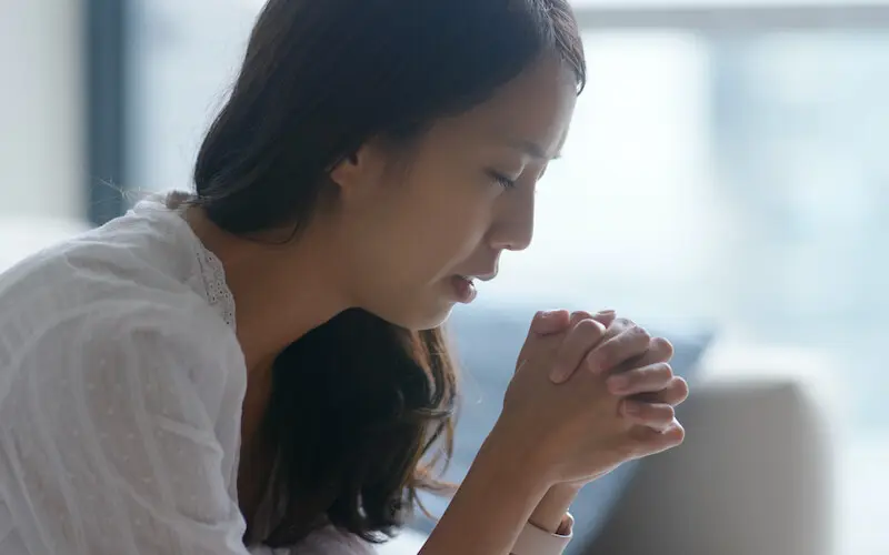how to ignite prayer showing an asian woman praying