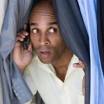 dangers of unconfessed sin showing a man hiding to make a phone call