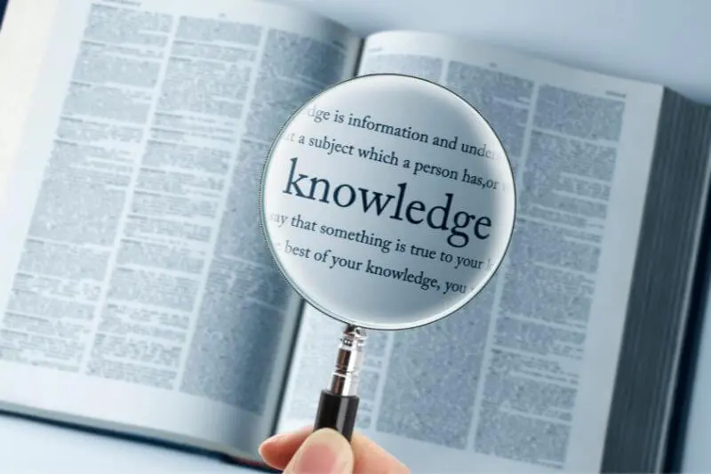 The Spirit of knowledge showing a magnifyign glass over the word knowledge